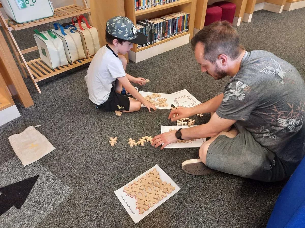 Families sharing play around a table at a community venue