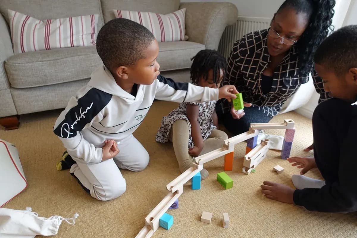 A family playing together with a wooden marble run